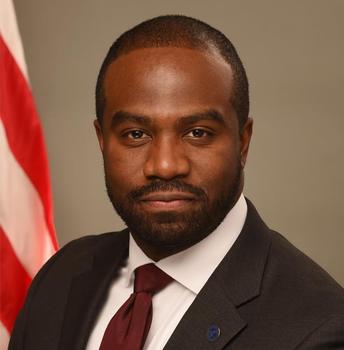 Marvin B. Figueroa in front of a U.S. Flag